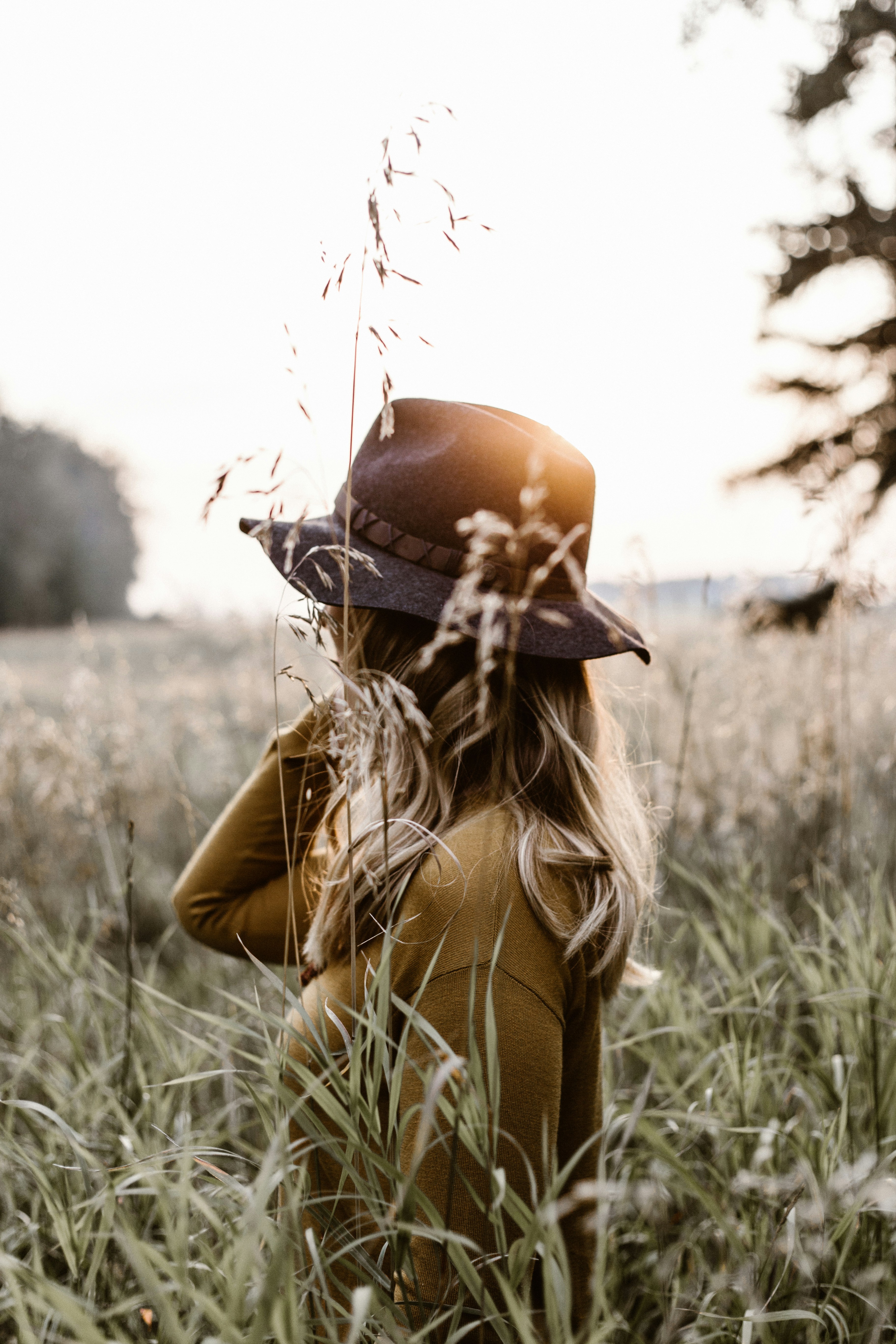 Woman in golden grass field at sunset