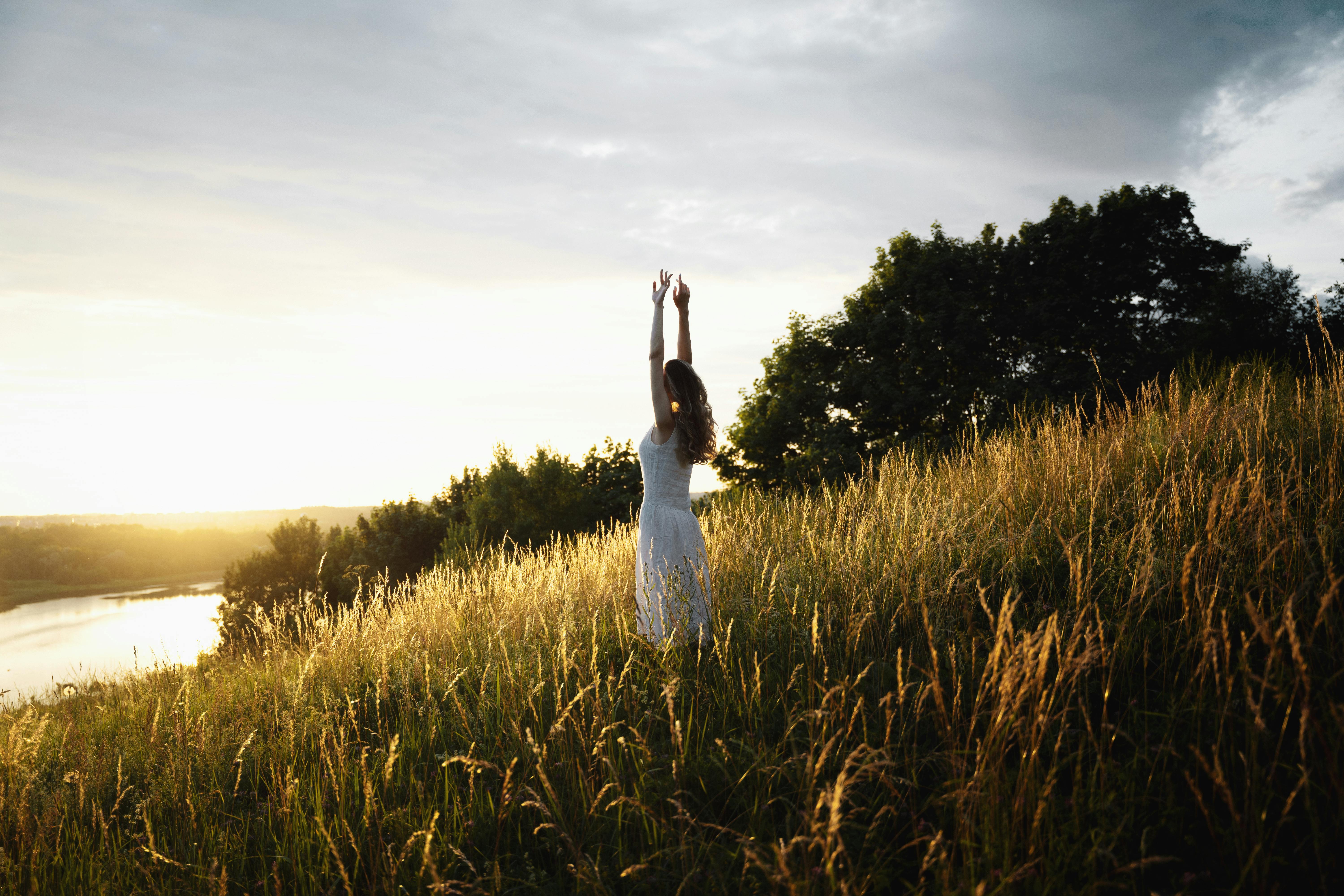 Woman embracing nature at golden hour